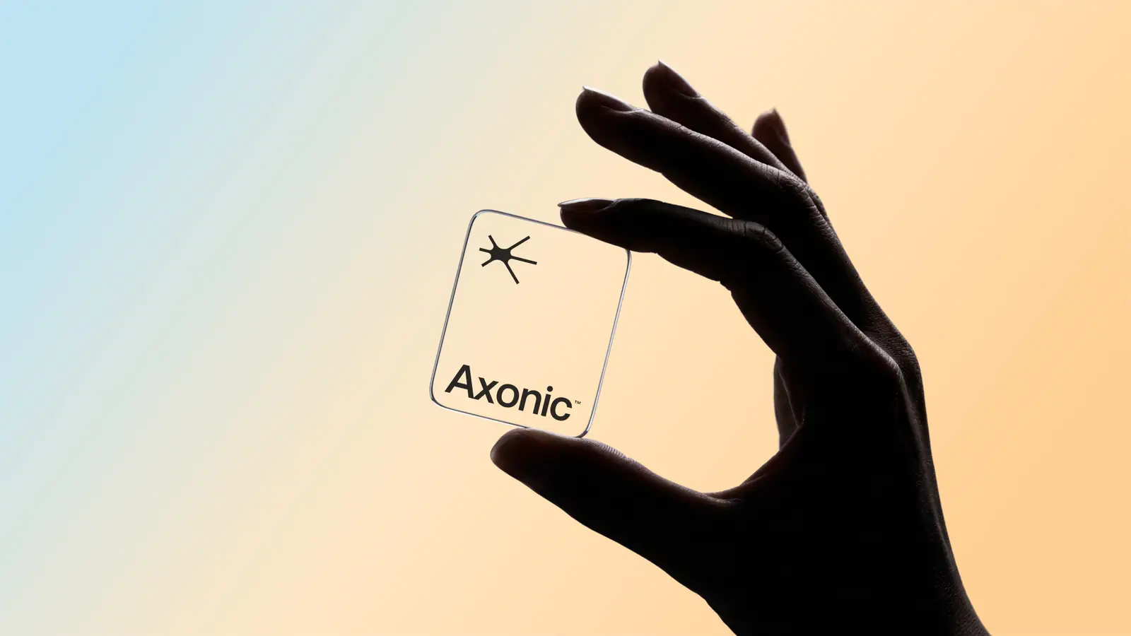 Mão segurando um cartão de vidro com o símbolo da Axonic sobre fundo degradê